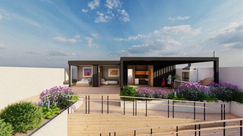 Casa con terraza de deck y jardín de flores moradas